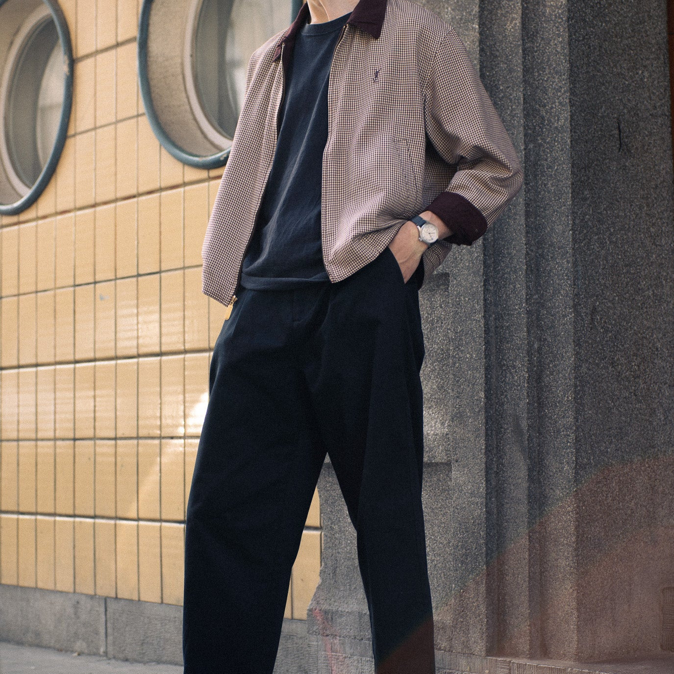 Winter look with black loafers, bright red Escuyer socks, black trousers and a yellow merino beanie, Brussels street