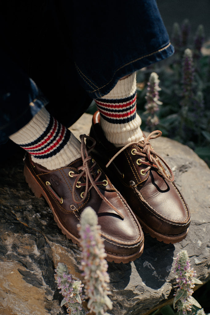Brown leather shoes from Timberland with striped socks from the brand Escuyer made in Portugal