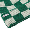 Side view of green and cream checkered knit merino beanie