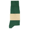 Green sock with a beige label on a white background