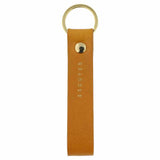 Escuyer mustard leather keychain — Italian vegetable tanned leather tab with gold metal ring and gold Escuyer logo