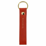 Escuyer orange leather keychain — Italian vegetable tanned leather tab with gold metal ring and gold Escuyer logo