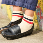 Woman wearing Escuyer striped ankle socks Red / Ochre with black loafers — spring summer style