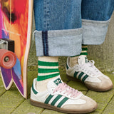 Woman wearing bright green and grey striped crew socks by Escuyer, made in Portugal