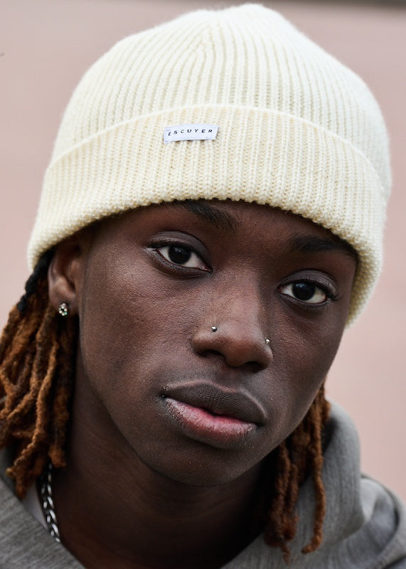 Person wearing a cream ribbed merino wool beanie by Escuyer