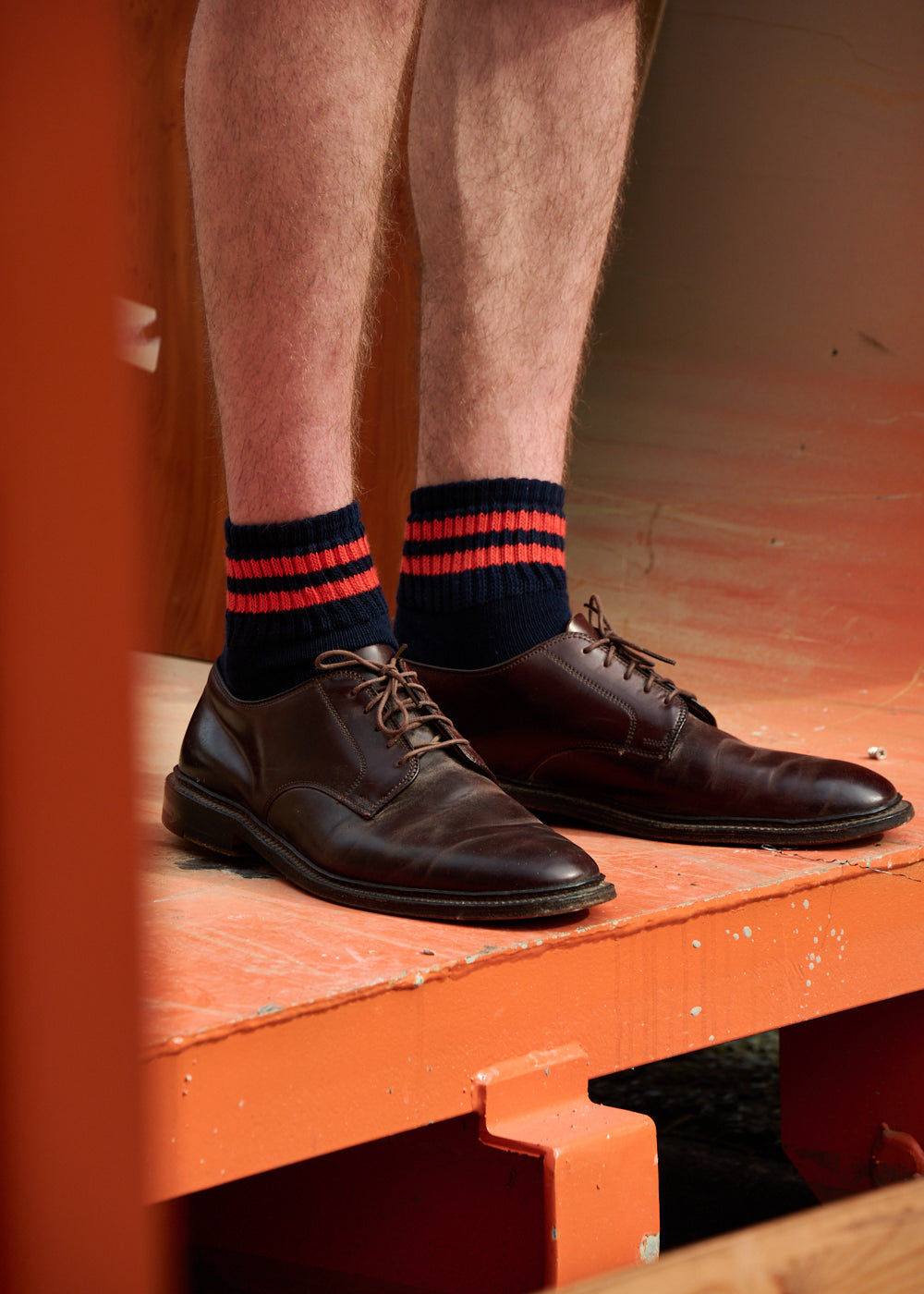 Man wearing Escuyer Men Striped Ankle Socks Orange / Ecru with brown loafers — vibrant summer style