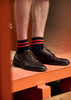 Man wearing classic brown shoes with red and navy striped ankle socks crafted from cotton yarns made in Portugal