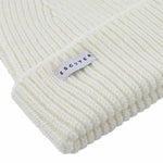 Side view of cream ribbed merino wool beanie with folded cuff